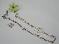 Conjunto com colar em corrente prateada, com aplicações de metal, contas tipo pérola e prateadas. Brincos a condizer. 
Preço: 6.50