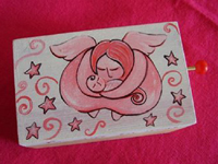 Caixa-de-música - La vie en rose: Caixa de madeira com aplicação de realejo (peça musical de manivela). Pintura em tinta acrílica. Acabamento em verniz transparente mate. Dimensões: 11cm x 5cm x 5cm (aprox.) / Tampa chata com fecho em iman. Preço: 12.00. Faço também pinturas personalizadas.