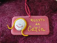 Placa com nome em parafina e boneca em pasta de modelar